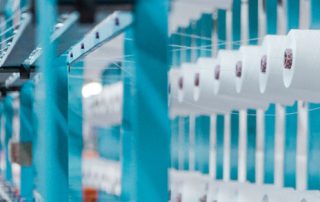 man working at machine in textile plant.